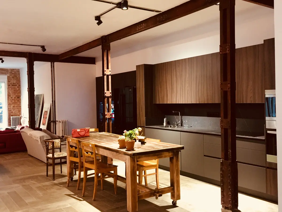Cocina y comedor con viga de madera vista.