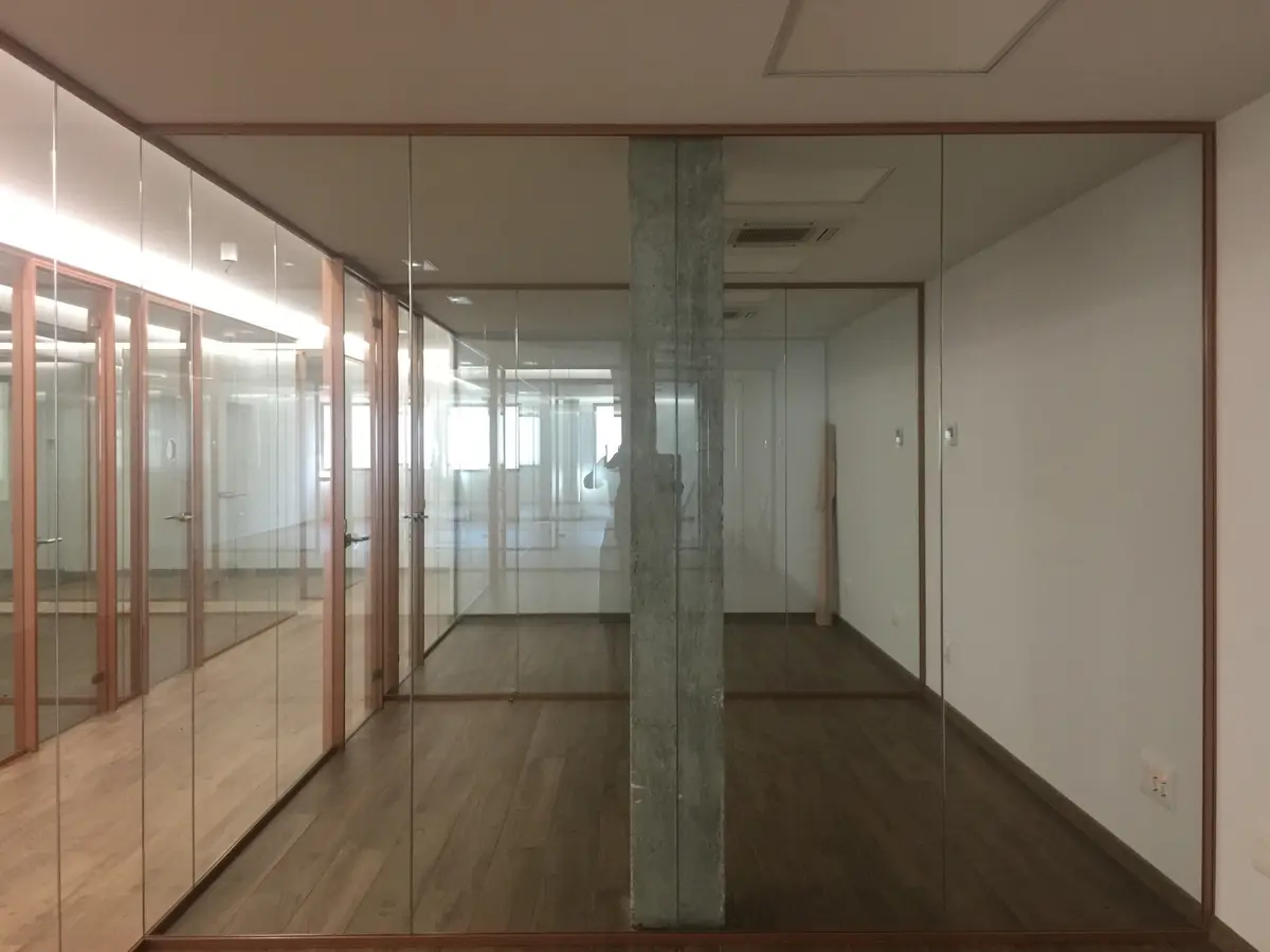 Sala de trabajo entre mamparas de vidrio.