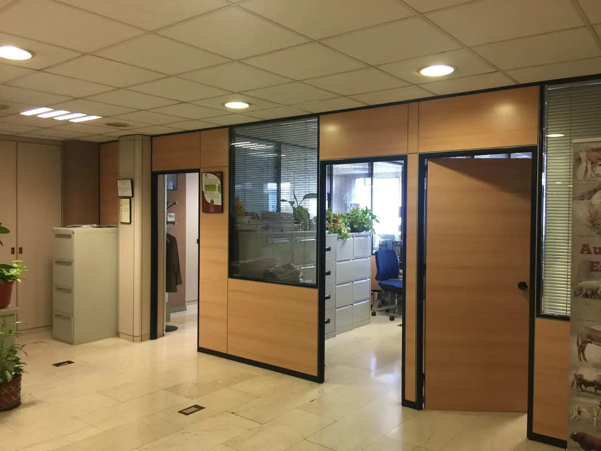 Entrada con paneles de madera y puerta acristalada.