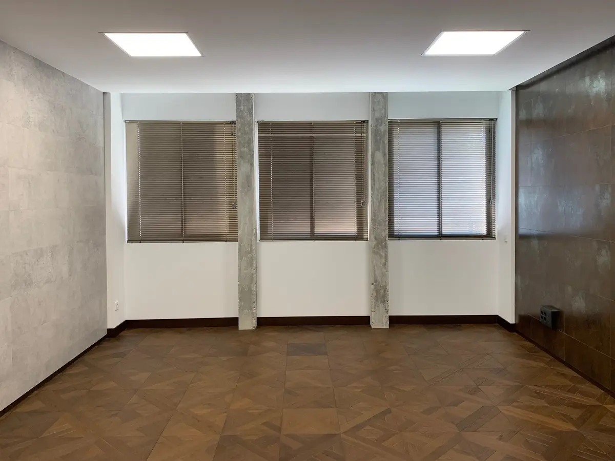 Sala con ventanas y suelo de parqué.